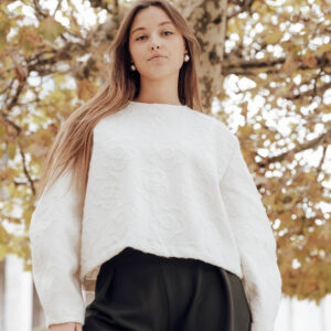 Deux femmes marchant dans un couloir lumineux, vêtues de créations Alibee Couture, entre mouvement et élégance.